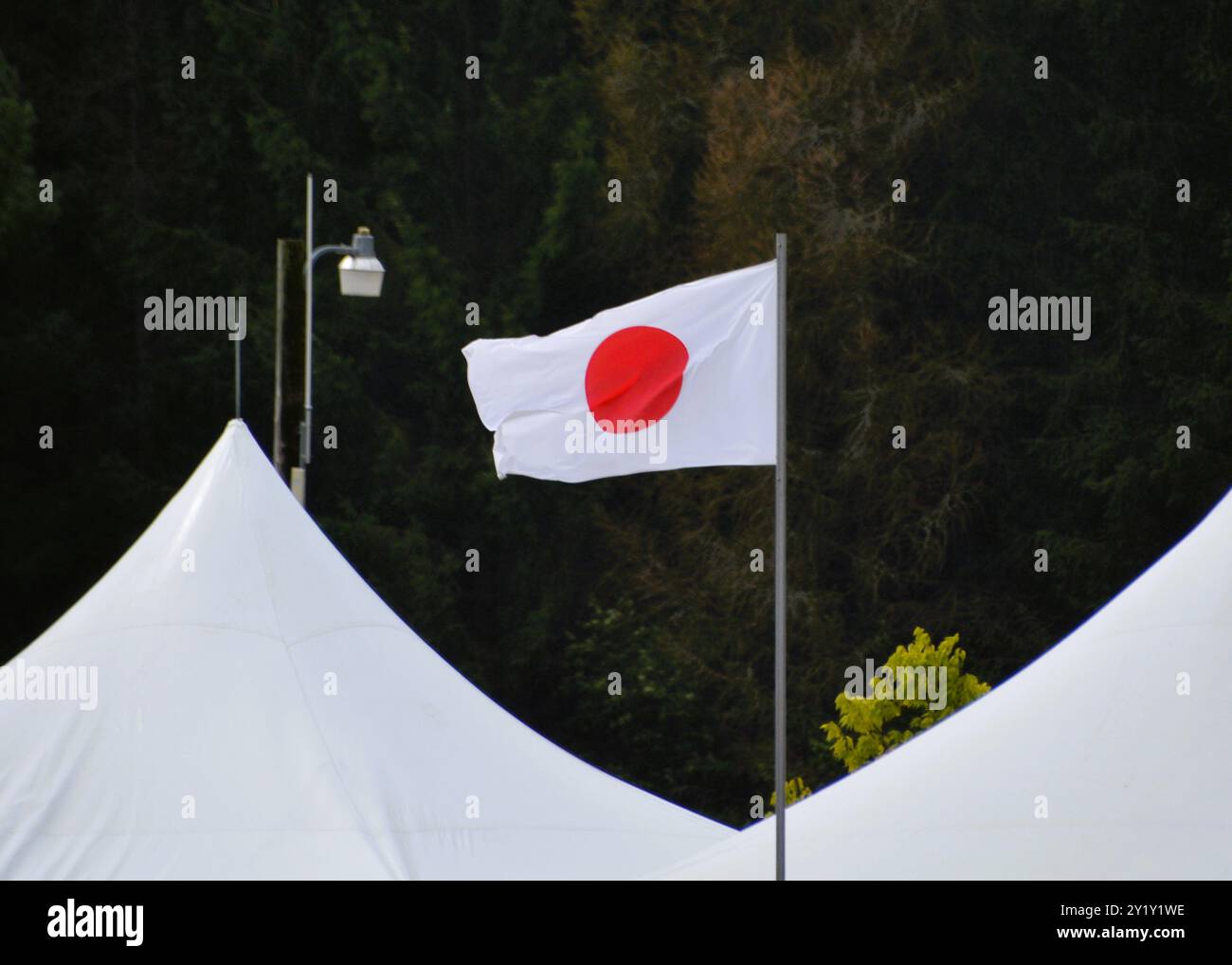 Le drapeau national du Japon volant dans la brise jusqu'à un mât de drapeau entre deux tentes blanches. Banque D'Images