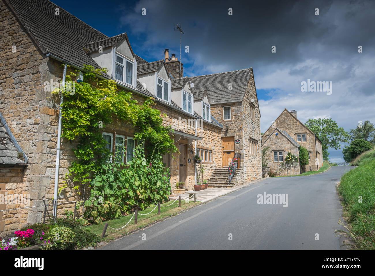 Charmants chalets en pierre sur la route du village Banque D'Images