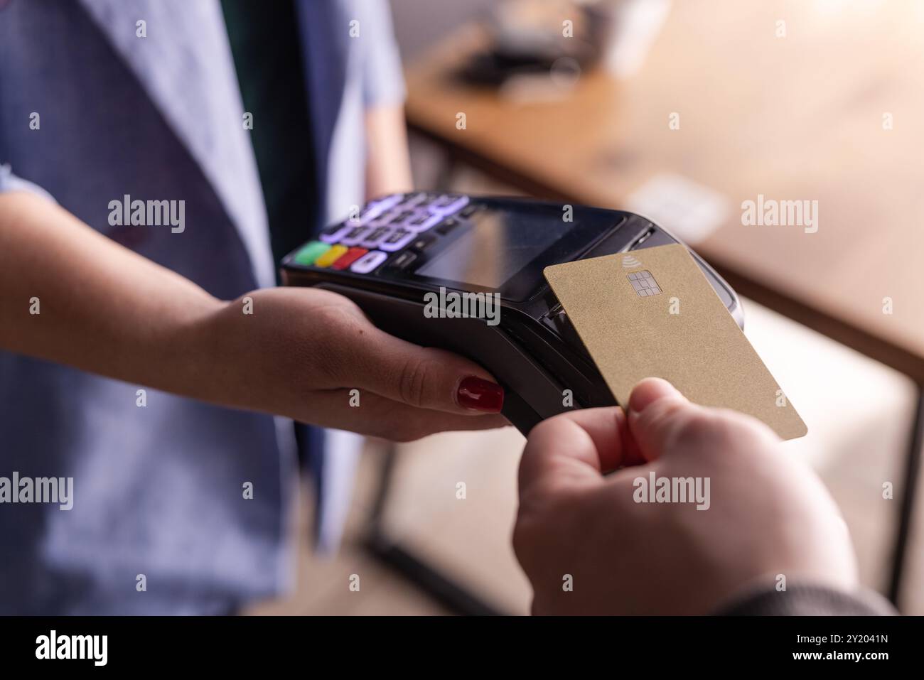 Paiement par carte de crédit NFC. Femme payant avec une carte de crédit sans contact avec la technologie NFC. Transaction monétaire sans fil. Machine à cartes dans la main masculine sur sunli Banque D'Images