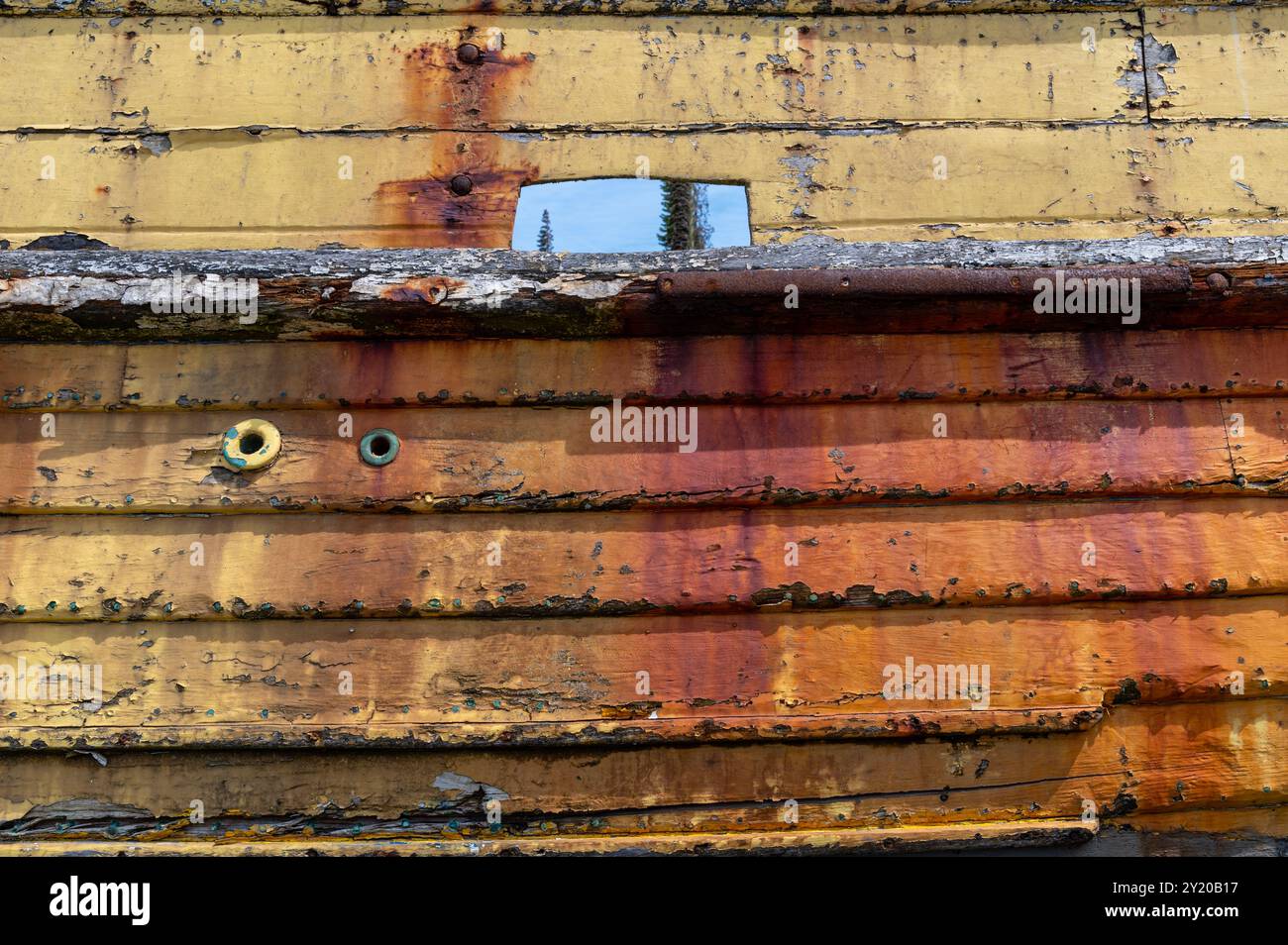 Côté rayé de rouille d'un bateau de pêche jaune en bois abandonné sur la plage de Hastings, au Royaume-Uni Banque D'Images