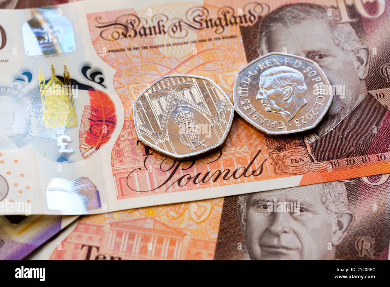Gros plan de billets britanniques de 10 livres et de pièces de 50 pence, représentant le portrait du roi Charles III, qui fait partie de la mise à jour 2024 de la monnaie britannique. Stafford, United Banque D'Images