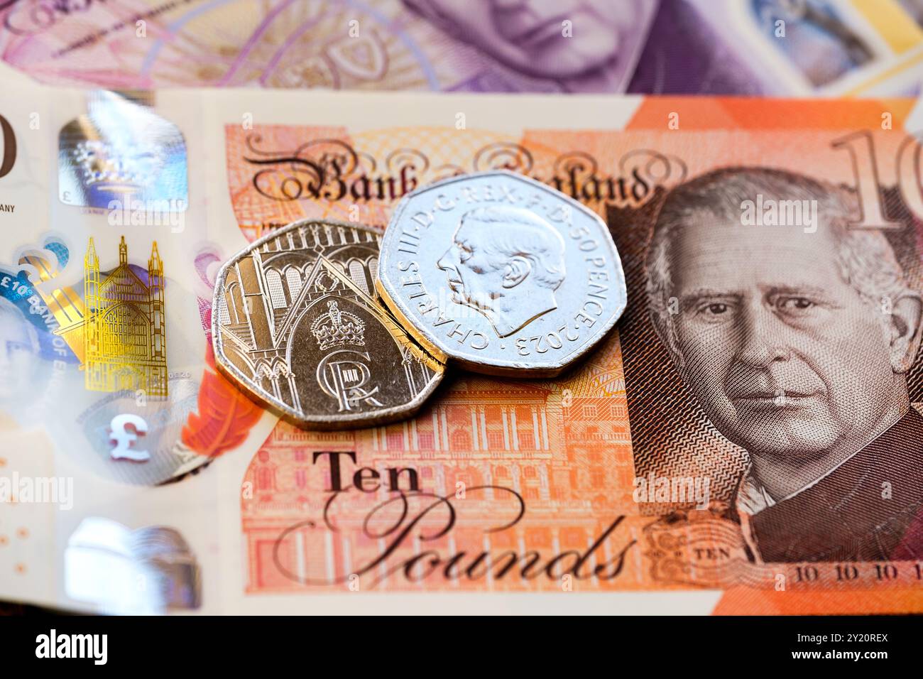 Gros plan des pièces et billets britanniques mettant en vedette le roi Charles III, en se concentrant sur les nouveaux designs de monnaie, y compris une pièce de 50 pence et un billet de 10 livres. Banque D'Images