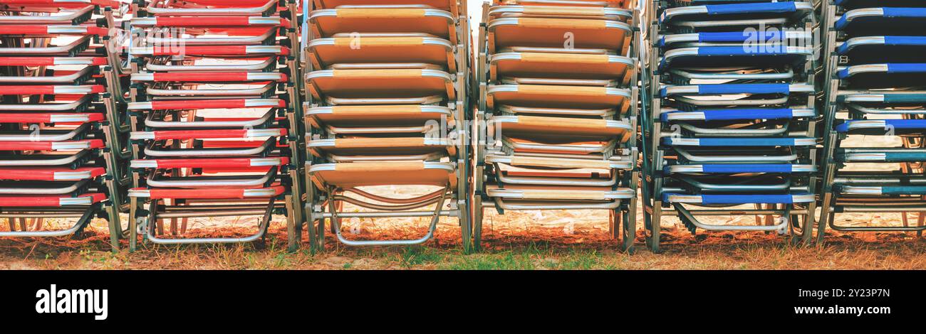 Chaises longues colorées empilées à la plage en été, modèle de vacances Banque D'Images