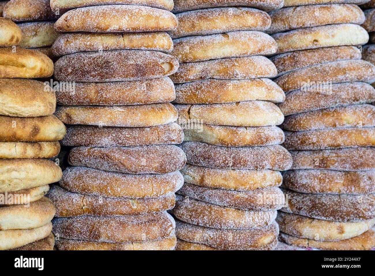 Pile de pain marocain frais à l'étal du marché de rue. Pain traditionnel fraîchement cuit appelé khubz, batbout, Mkhamer ou harcha au Maroc Banque D'Images