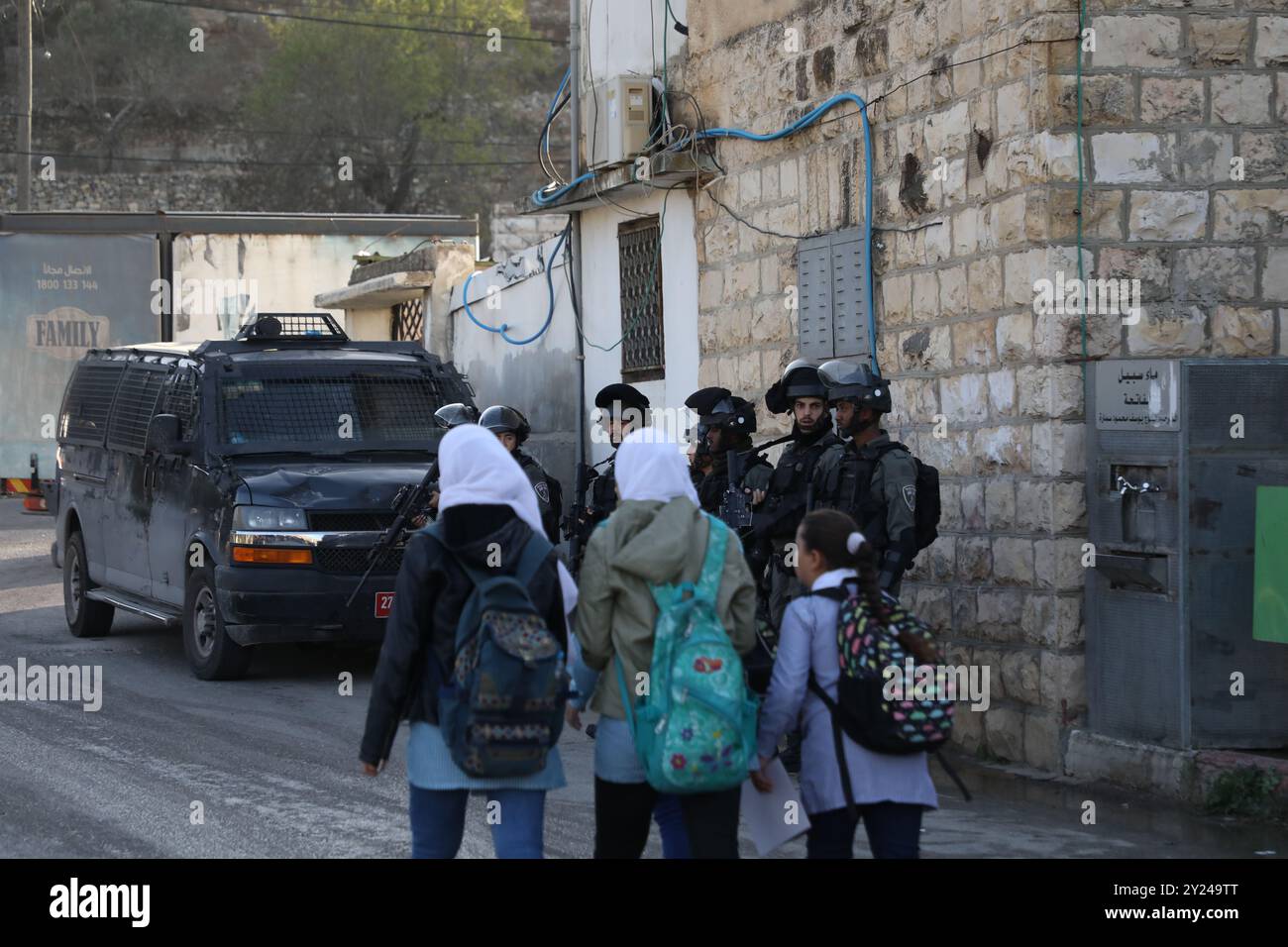 Naplouse, Palestine. 28 novembre 2021. Des écoliers palestiniens marchent sur le chemin de l'école sous l'œil vigilant des soldats israéliens dans le village de Lubban Ash-Sharqiya, au sud de Naplouse. Le village et les écoles ont récemment été attaqués quotidiennement par des colons juifs israéliens, qui ont également tenté d’entraver l’accès des élèves à l’école. Les habitants organisent des manifestations contre la violence des colons, les forces israéliennes réprimant les manifestations et arrêtant certains de leurs participants Banque D'Images