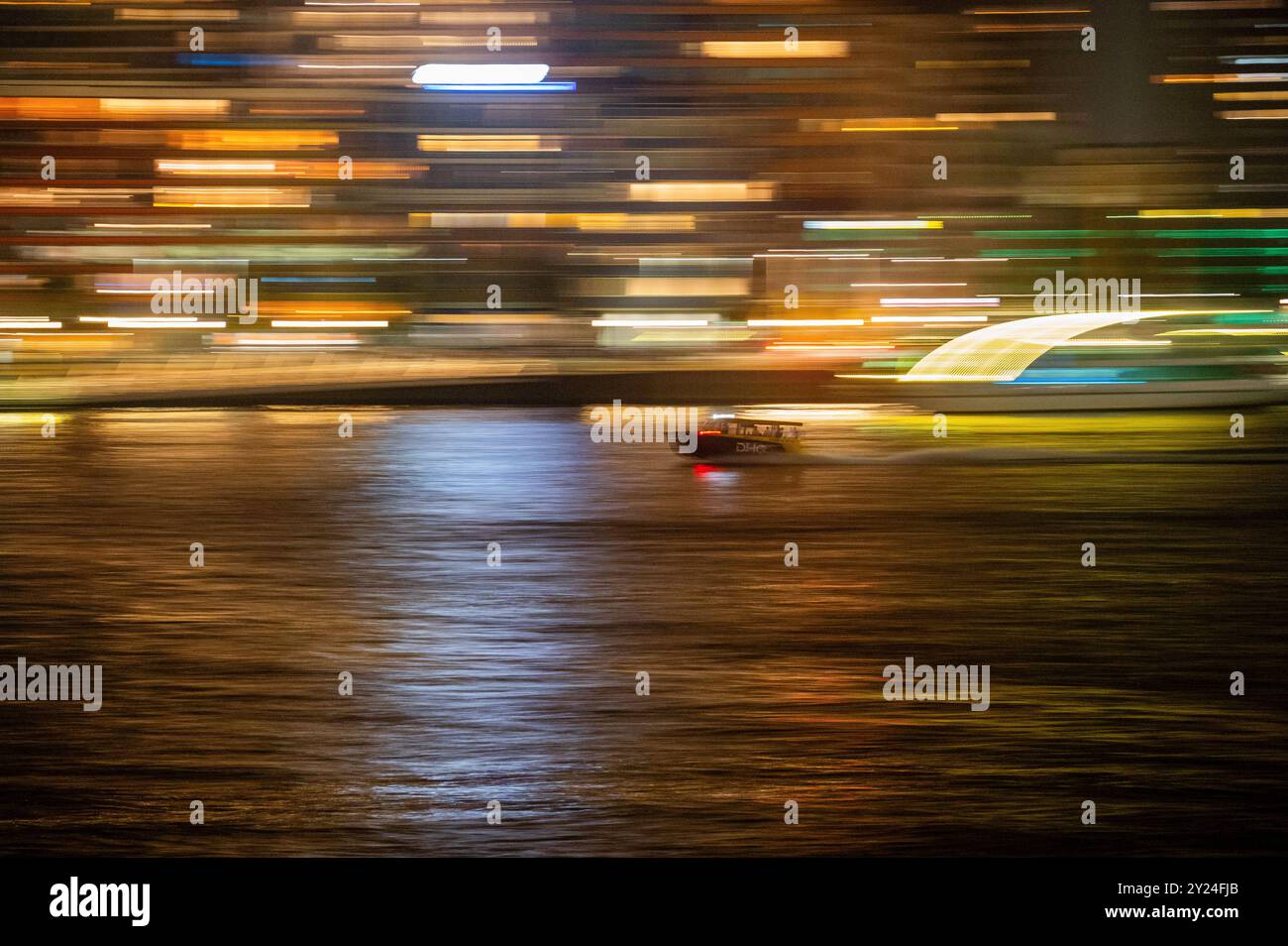 Vitesse de bateau-taxi à travers le port fluvial de la ville la nuit, panoramique flou à grande vitesse Banque D'Images