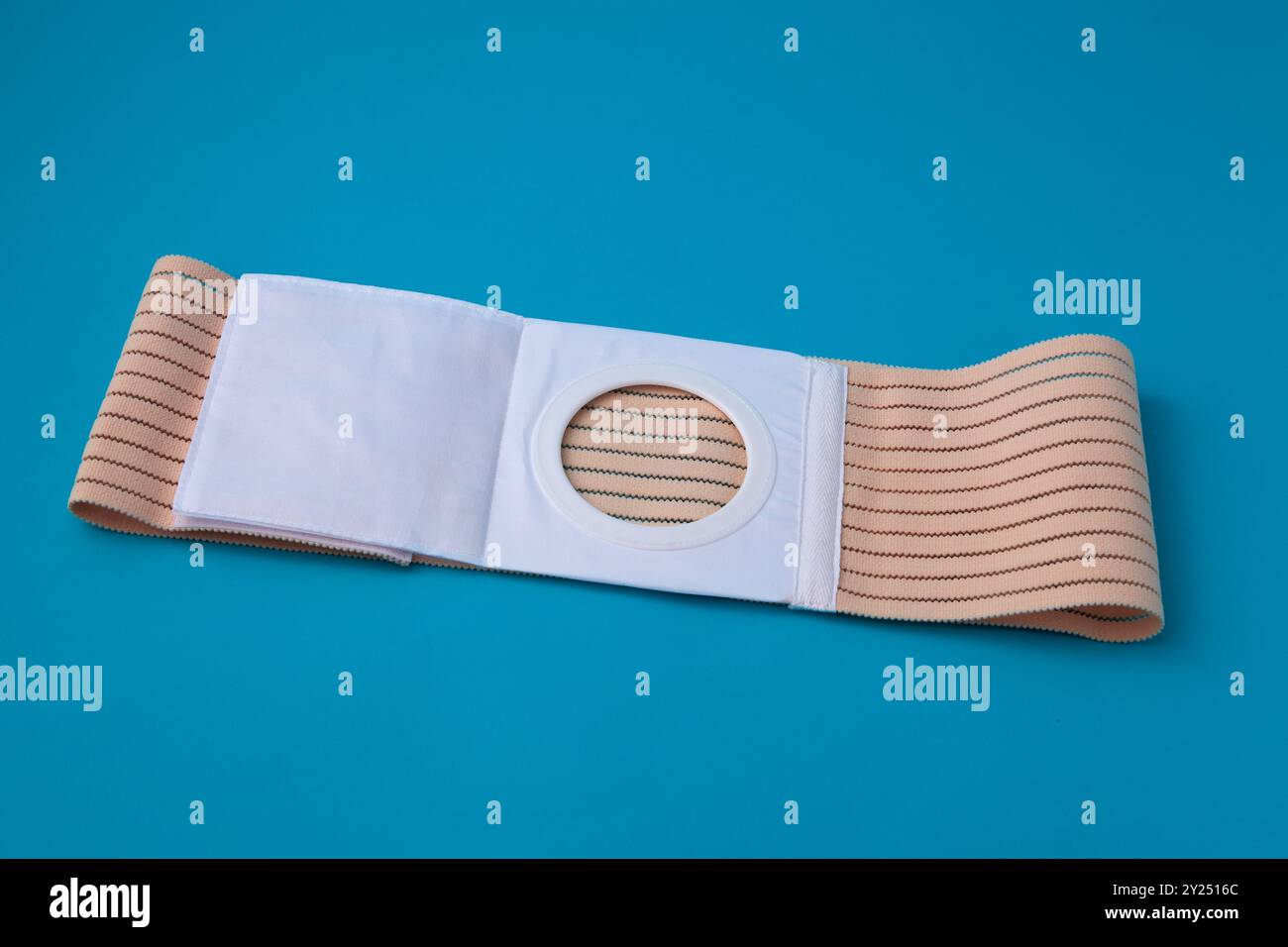 ceinture abdominale dépliée avec ouverture de stomie pour les patients ayant subi une colostomie sur fond bleu Banque D'Images ceinture abdominale dépliée avec ouverture de stomie pour les patients ayant subi une colostomie sur fond bleu Banque D'Images