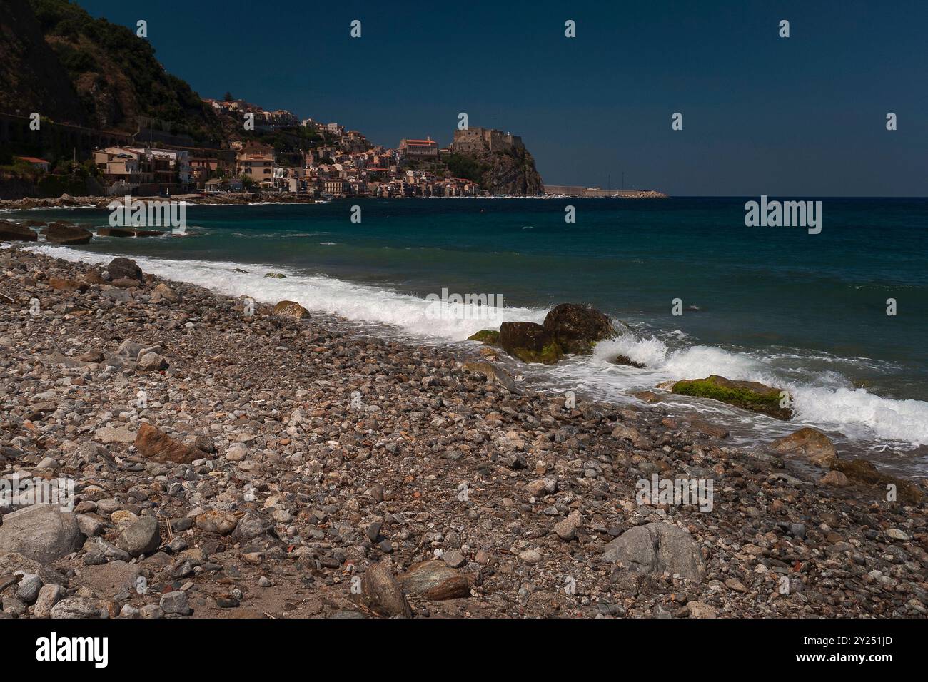 Sur un promontoire rocheux surplombant la mer Tyrrhénienne et le détroit de Messine, le château médiéval Ruffo di Calabria et, à gauche du château, la ville de Scilla en Calabre, Italie. Selon la légende grecque et romaine, le monstre marin Scylla hantait les rochers ici, en face du tourbillon Charybde. Immédiatement à gauche du château se trouve une église reconstruite dans les années 1950, la Chiesa dell’Immacolata. Banque D'Images