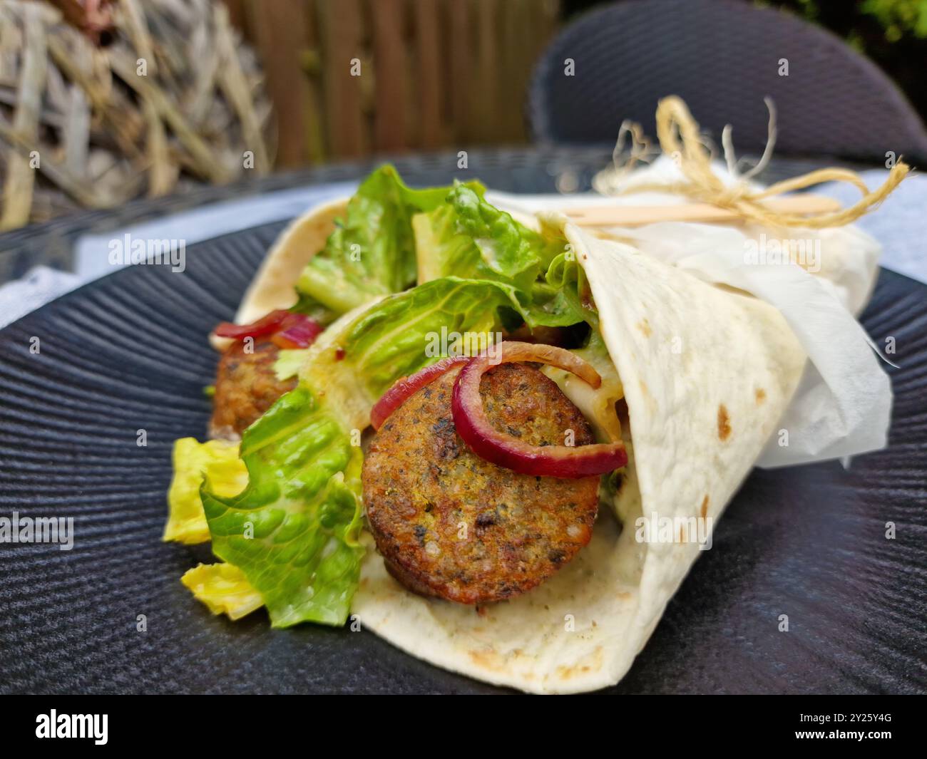 Wrap végétalien Falafel avec salade fraîche et oignons rouges caramélisés Banque D'Images