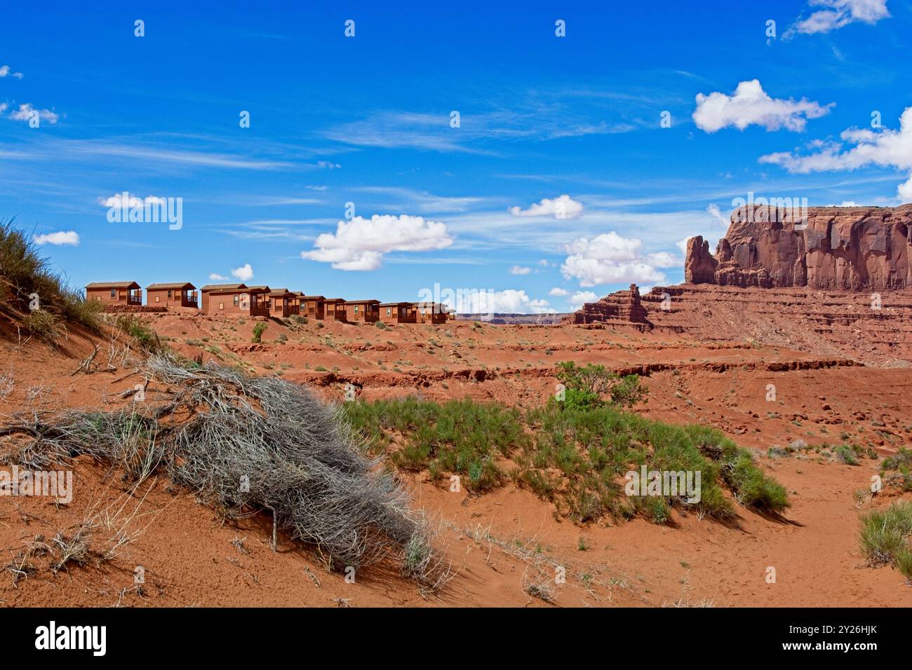 Sentinel Mesa s'élève au-dessus d'une rangée de cabanes le long de la jante de Monument Valley - Arizona, avril 2024 Banque D'Images