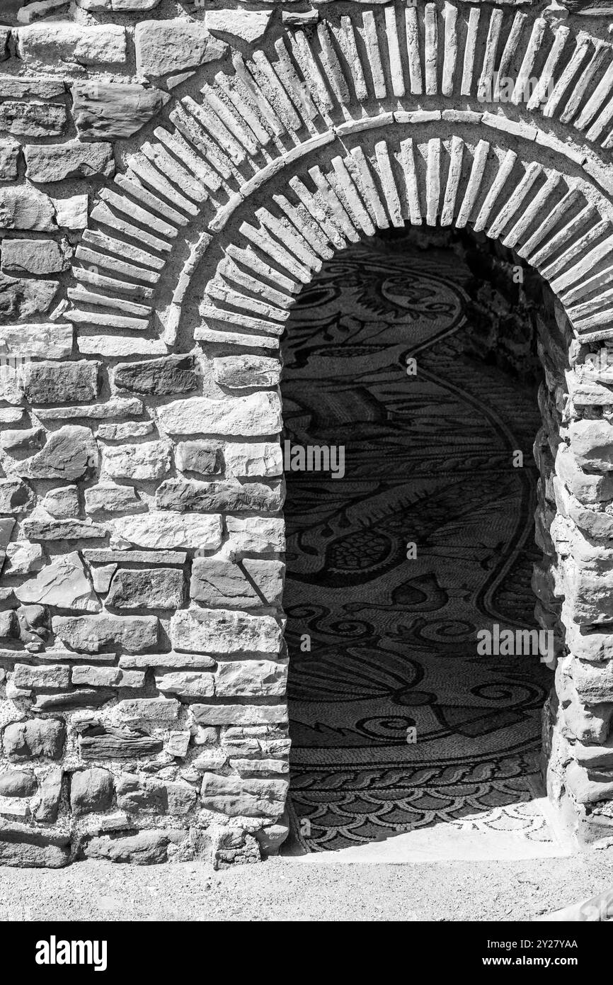 Arch Frame Mosaic dans les ombres : lumière et ombre sur un fond de mur de pierre. Banque D'Images