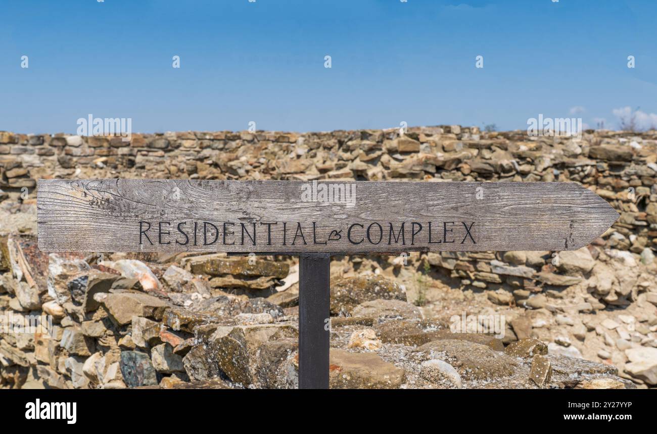 Complexe résidentiel signe : lettres peintes en noir, flèche en bois contre les rochers et ciel bleu. Banque D'Images