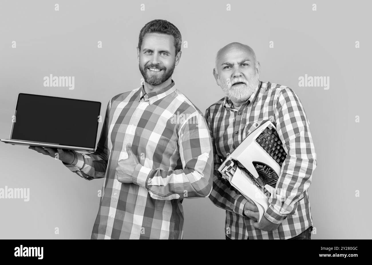 photo de l'émission de l'écrivain vs contraste avec l'ordinateur portable et la machine à écrire rétro, pouce vers le haut. Banque D'Images