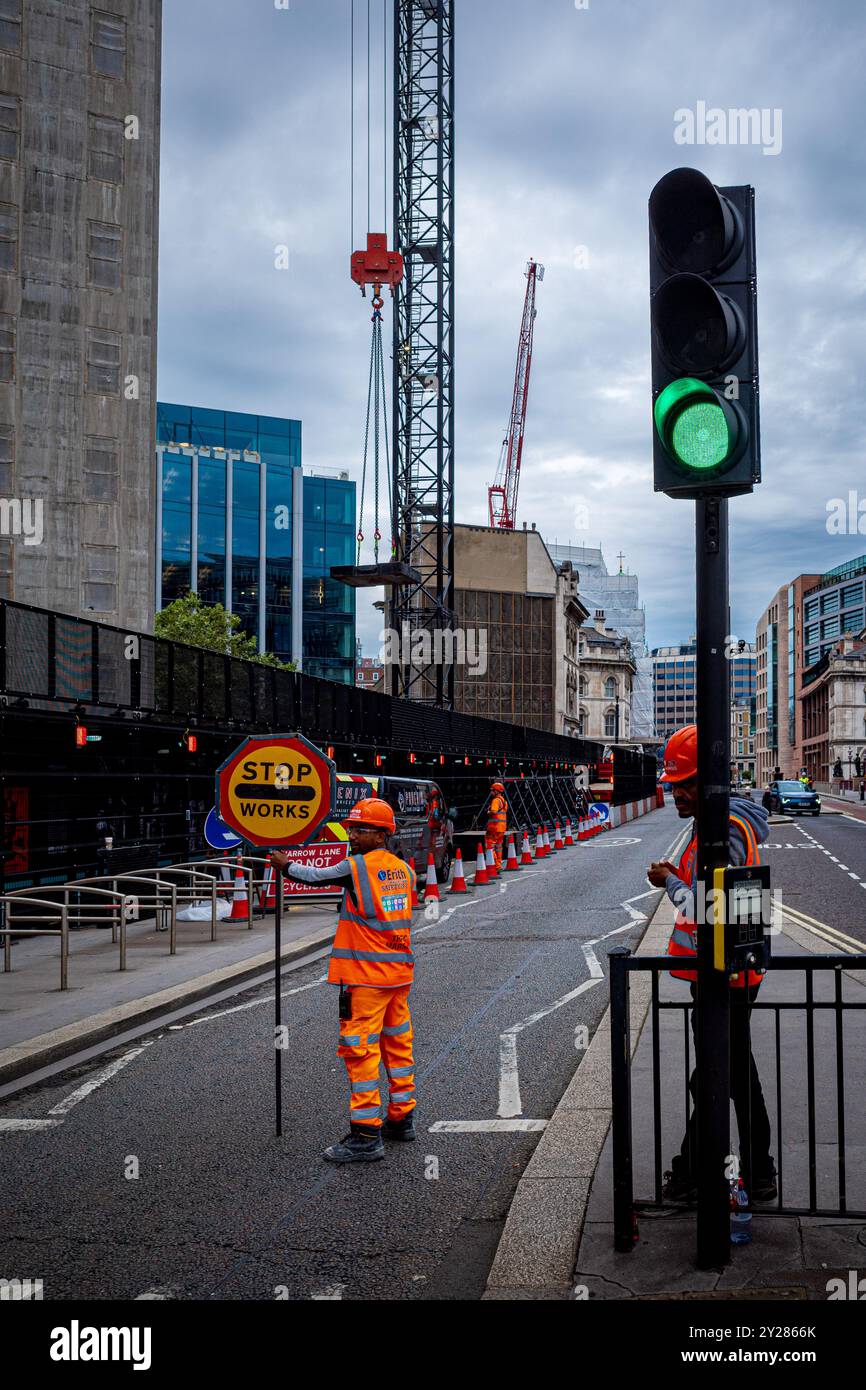 Contrôle de la circulation des travaux de construction dans la ville de Londres Royaume-Uni. Contrôle manuel du trafic par les ouvriers du bâtiment pour le travail de pont roulant. Banque D'Images