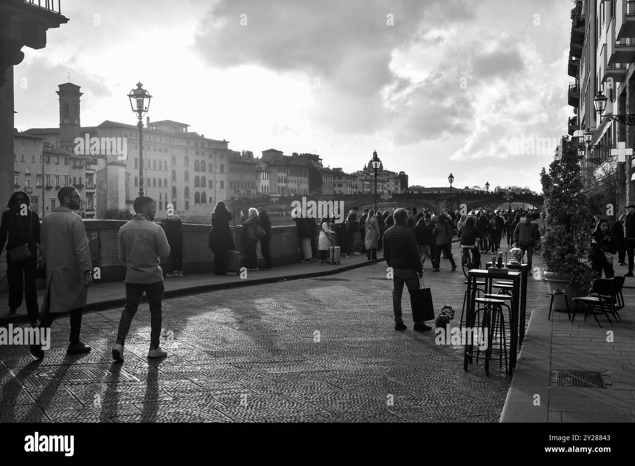 Noir et blanc. Touristes marchant sur le Lungarno degli Acciaiuoli, un tronçon de route le long de la rivière Arno, le lundi de Pâques, Florence, Toscane, Italie Banque D'Images