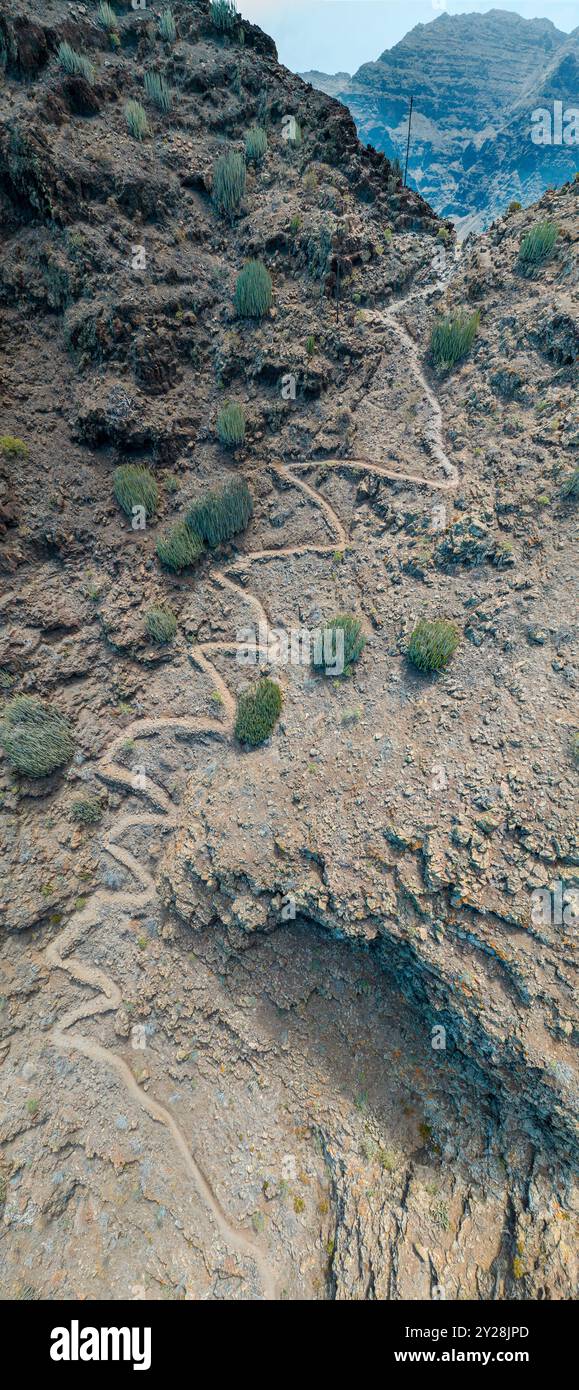 Vue aérienne du sentier à travers les montagnes jusqu'à la plage de Guigui, plage de sable noir immaculé, Gran Canaria. Espagne. Sentier pittoresque Banque D'Images