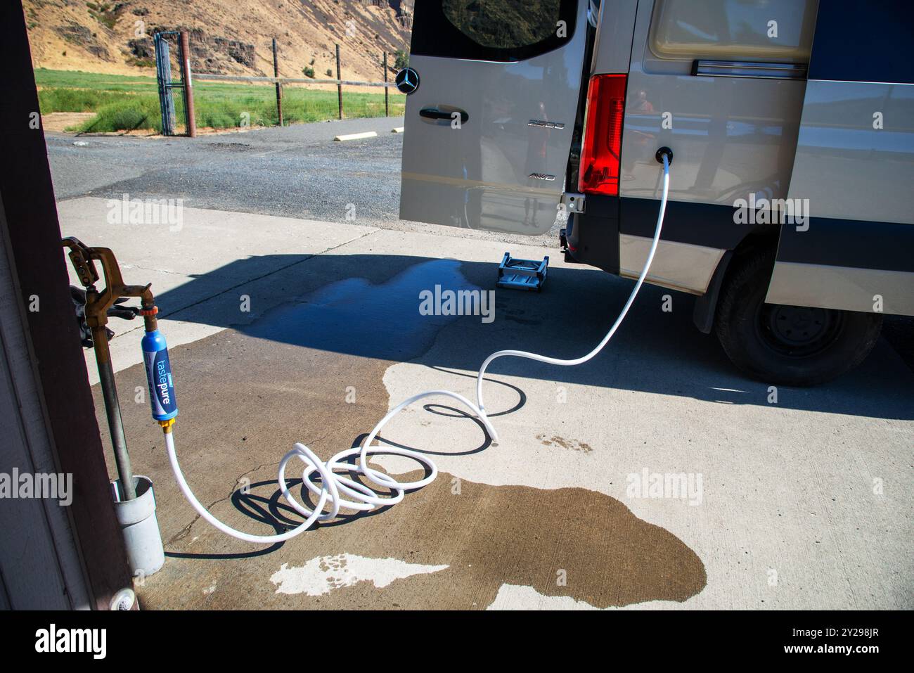 Utilisation d'un tuyau propre sans produit chimique pour remplir un réservoir d'eau sur un camping-car Mercedes Benz sprinter RV à Naches, Washington. ÉTATS-UNIS Banque D'Images