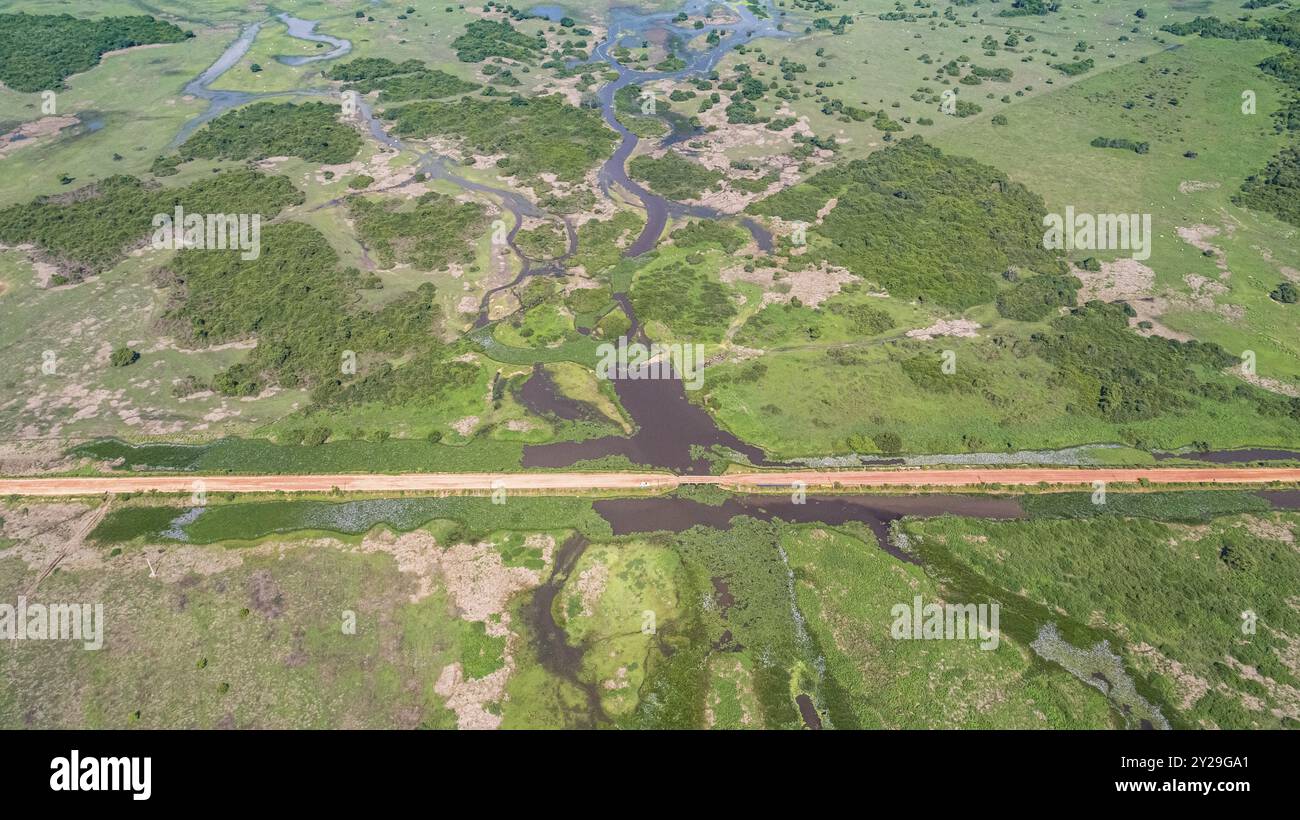 Vue aérienne de Transpantaneira route de terre traversant un lagon au-dessus d'un petit pont dans le paysage typique de North Pantanal Wetlands, Mato Grosso, Brazi Banque D'Images