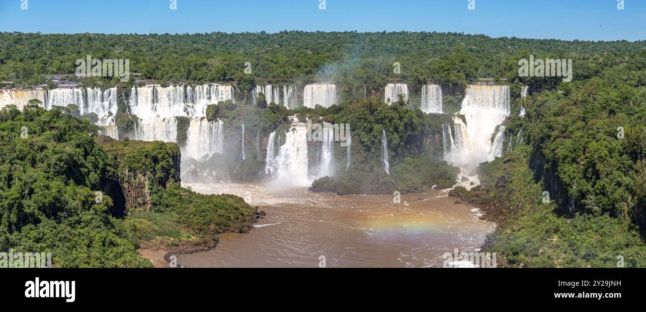 Vue panoramique sur la cascade spectaculaire des chutes d'Iguazu sous le soleil et la rivière brune, Argentine, Amérique du Sud Banque D'Images