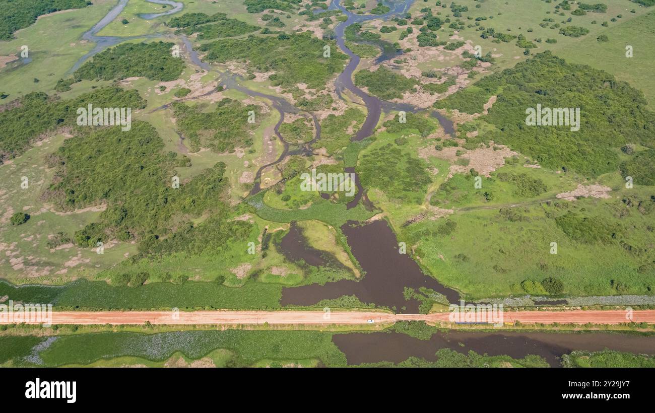 Vue aérienne de Transpantaneira route de terre traversant un lagon au-dessus d'un petit pont dans le paysage typique de North Pantanal Wetlands, Mato Grosso, Brazi Banque D'Images