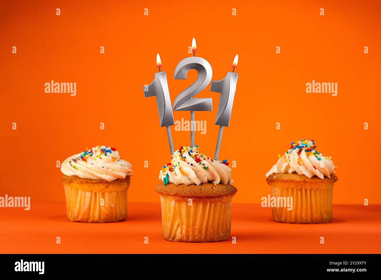 Bougie numéro 121 - célébration avec cupcake d'anniversaire sur fond orange Banque D'Images