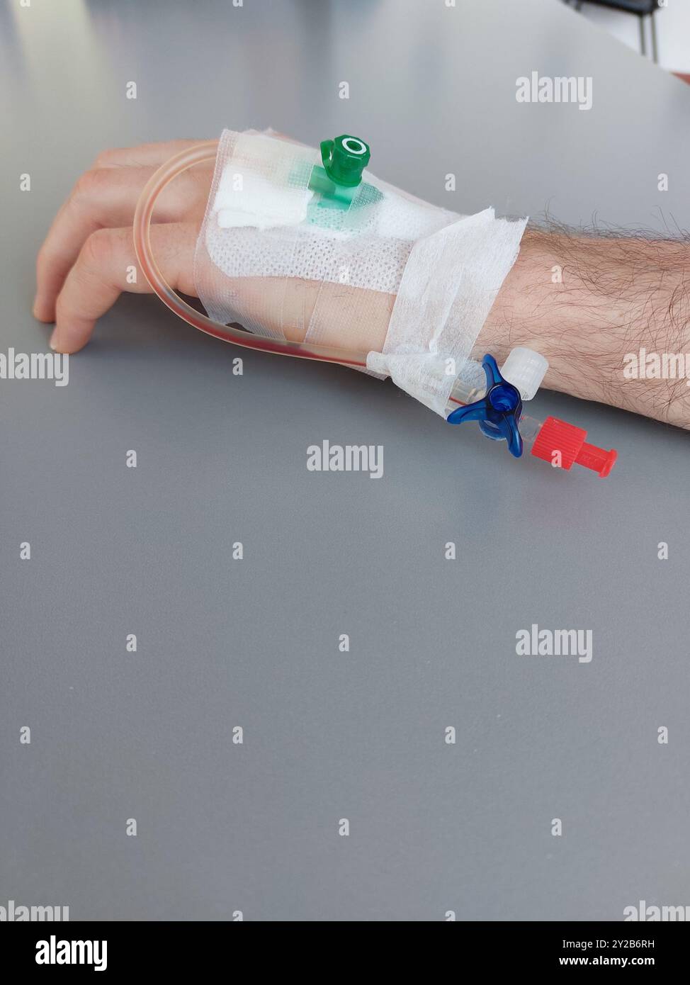 Main avec goutte médicale après opération hospitalière, tir vertical Banque D'Images