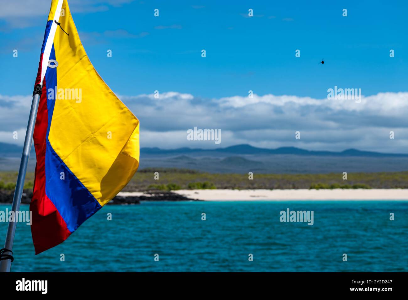 Drapeau de l'Équateur sur le bateau avec vue sur la plage de sable, île de Santa Cruz, Galapagos Banque D'Images