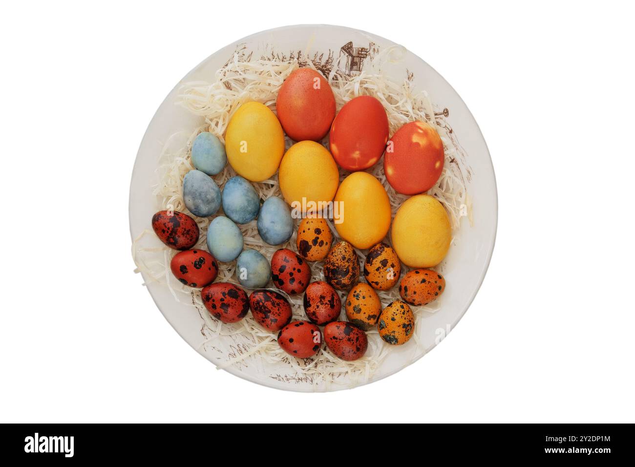 Oeufs de Pâques dans une assiette rustique. Isolez sur un fond blanc. Traditions de Pâques. Variété d'œufs peints. Décoration. Style campagnard. Vue de dessus. Banque D'Images