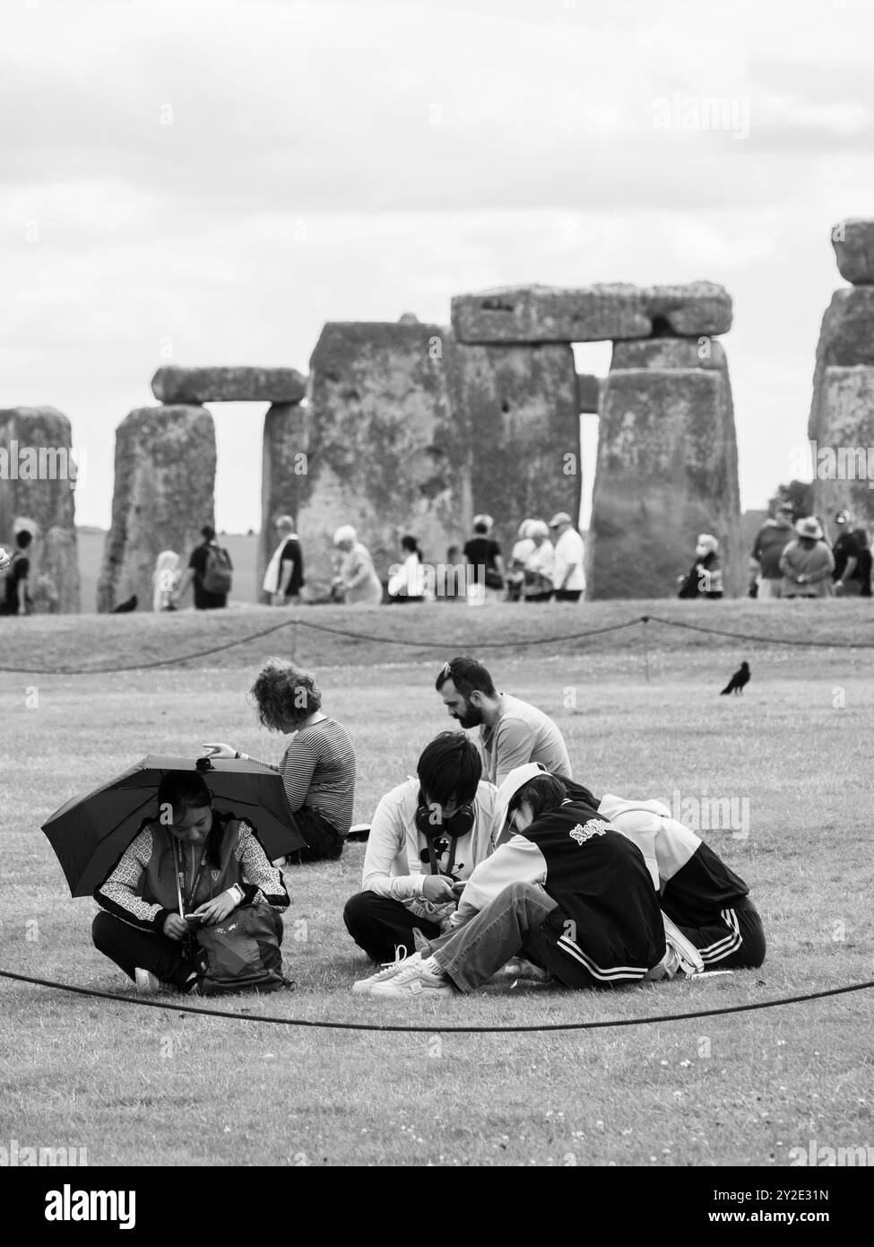 Touristes se relaxant à Stonehenge, Wiltshire, Angleterre, Royaume-Uni, GB. Banque D'Images