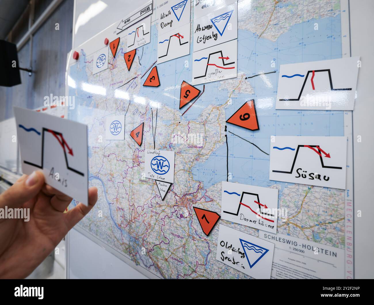 Kiel, Allemagne. 10 septembre 2024. Un pompier se tient debout devant une carte d'ensemble du Schleswig-Holstein dans la zone opérationnelle lors d'un événement de presse pendant l'exercice de planification de l'équipe de crise pour le scénario «onde de tempête de la mer Baltique». Avec un exercice de planification, les travailleurs des secours en cas de catastrophe se préparent jusqu’à jeudi à Kiel pour un déploiement en cas de grave onde de tempête en mer Baltique comme celle d’octobre. Crédit : Christian Charisius/dpa/Alamy Live News Banque D'Images