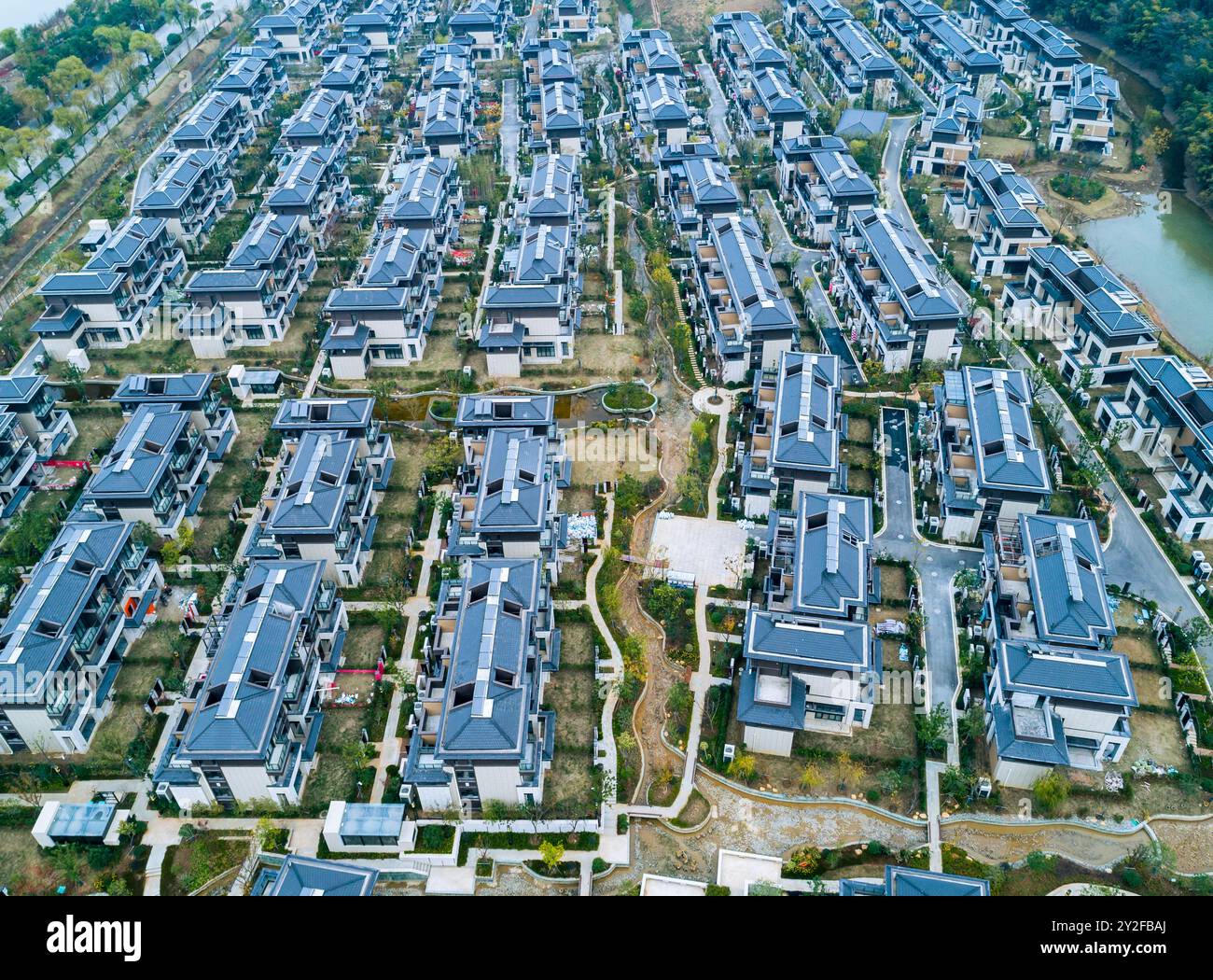 Vue aérienne d'une vaste communauté résidentielle avec des maisons modernes et des jardins paysagers dans une banlieue pendant la journée Banque D'Images
