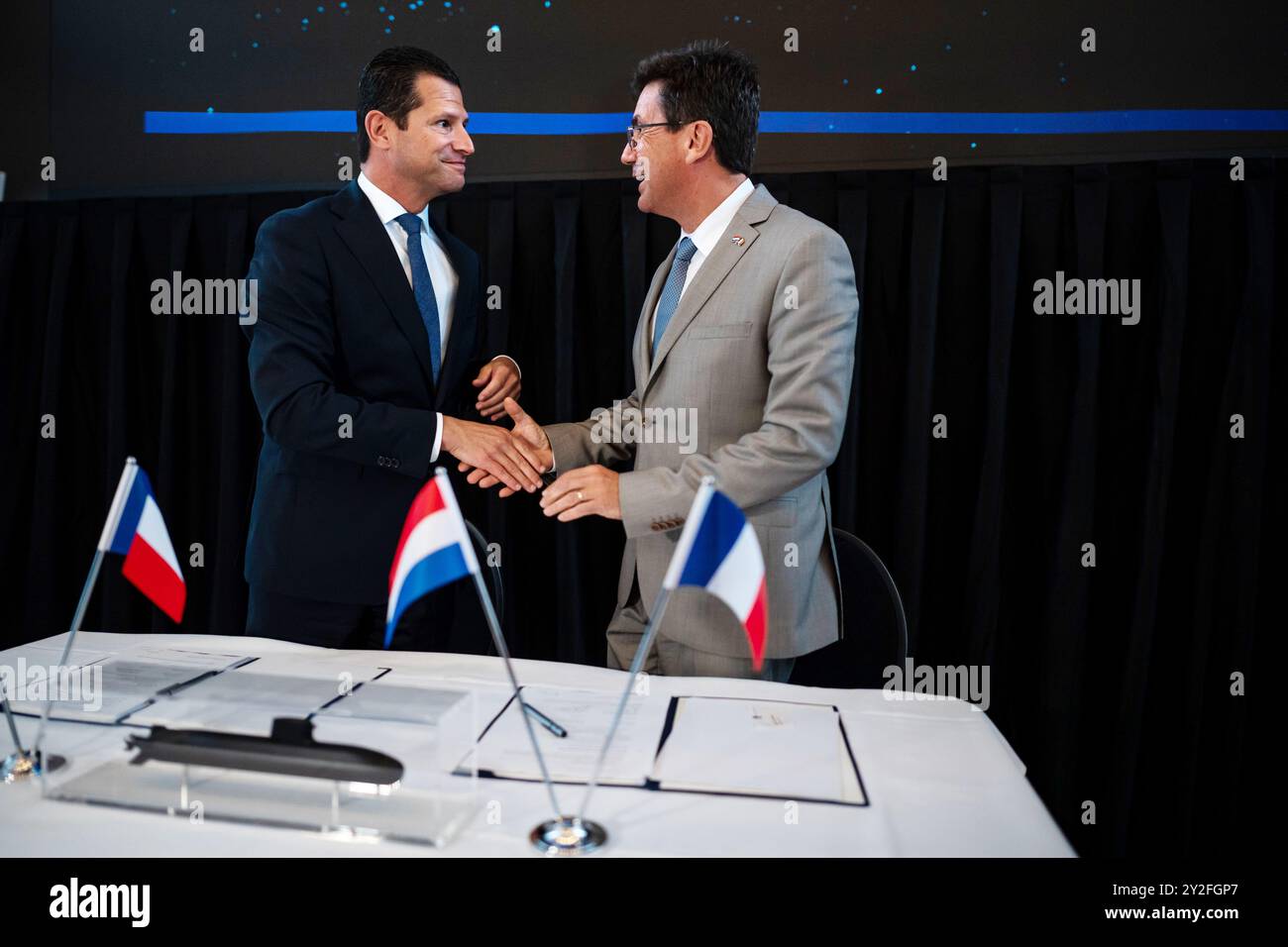 DEN HAAG - Dirk Beljaarts (à droite), ministre de l'économie et Pierre-Eric Pommellet (à m), président du conseil d'administration du groupe Naval, lors de la signature au ministère de l'économie d'un accord de coopération industrielle. Après la signature de cette ICA, un contrat final de fourniture peut alors être conclu par la Défense. ANP LINA SELG pays-bas Out - belgique Out Banque D'Images