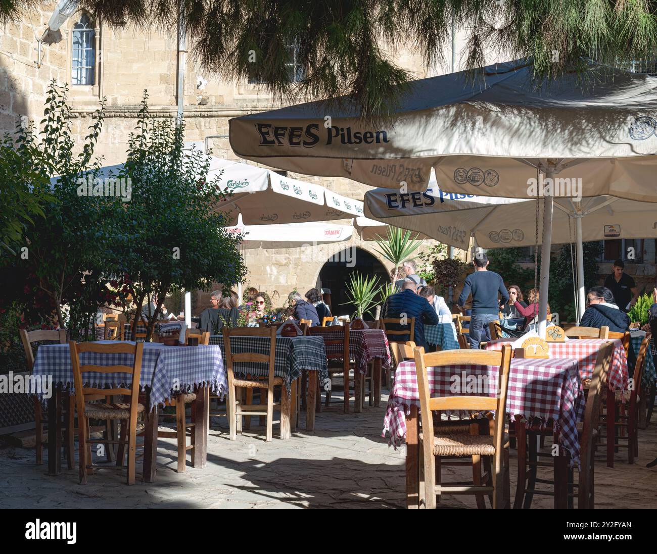 Nicosie, Chypre - 03 décembre 2015 : les gens profitent d'une journée ensoleillée dans un café en plein air derrière la mosquée Selimiye Banque D'Images