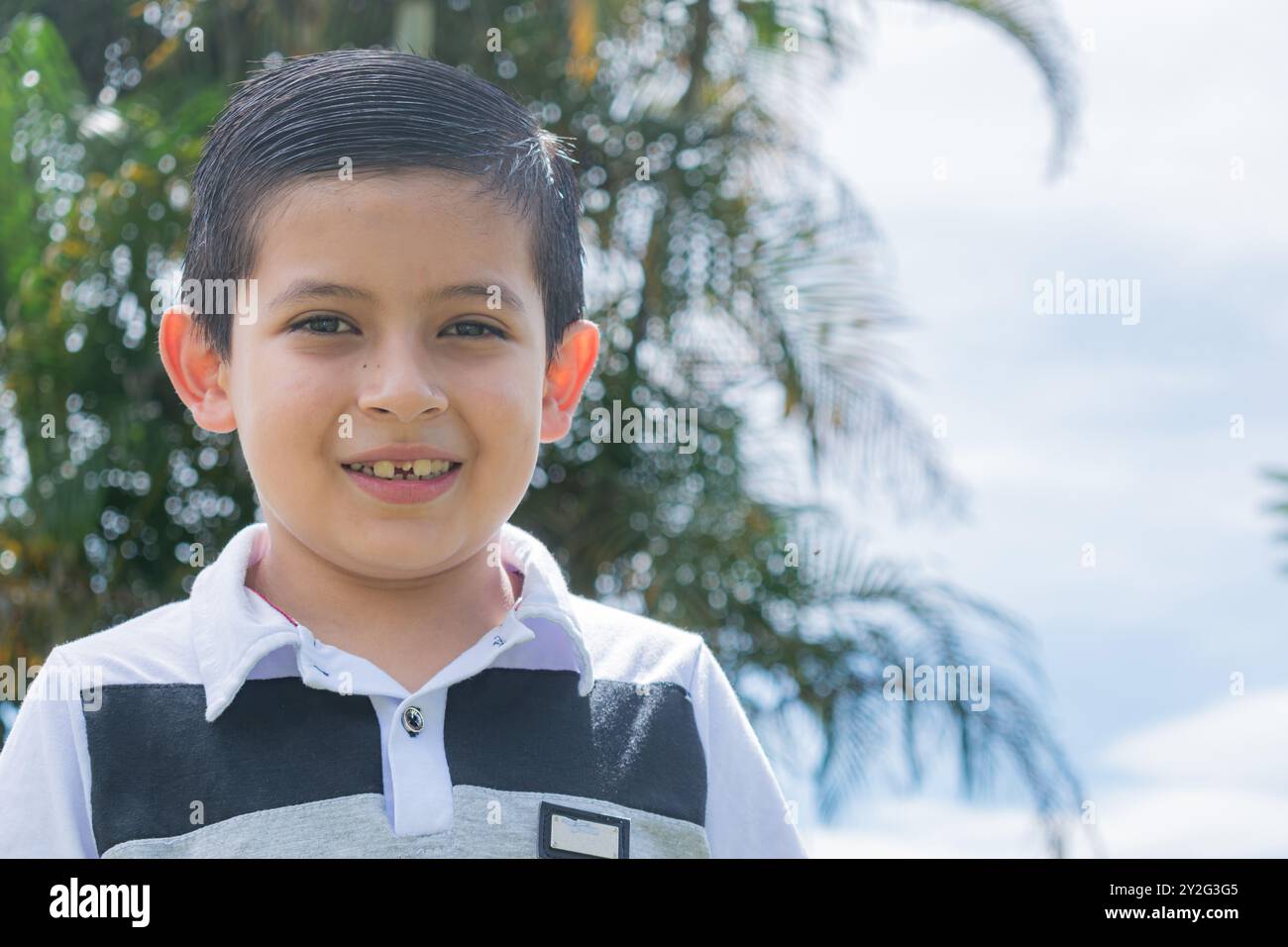 Portrait d'un garçon latino-américain colombien souriant à la caméra par une journée ensoleillée à la campagne, avec un espace pour le texte sur le côté droit Banque D'Images