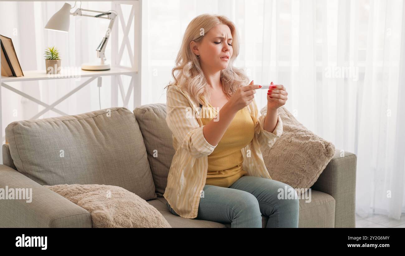 Échec de la grossesse. Femme bouleversée. Regret de déception. Dame pleine d'espoir cherchant à obtenir le résultat d'un test médical assis à l'intérieur de la salle de lumière. Banque D'Images