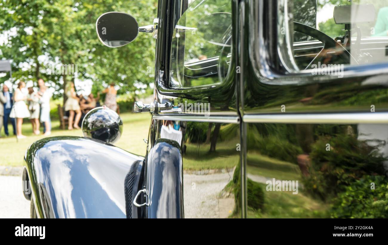 Reflet des célébrations de mariage sur une voiture vintage noire classique Banque D'Images