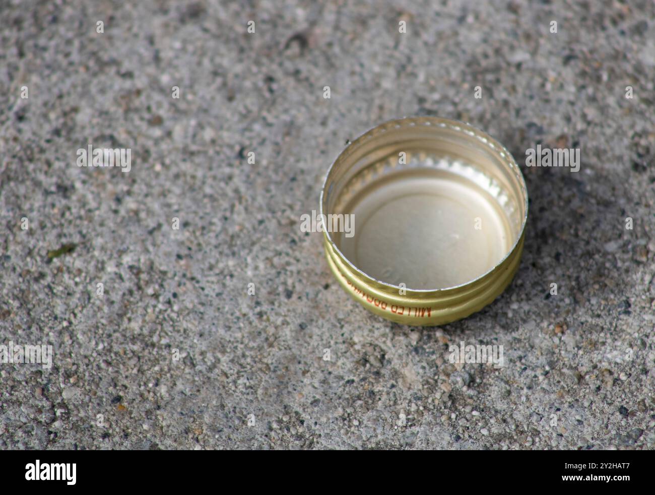 bouchon de bouteille or sur sol pavé Banque D'Images