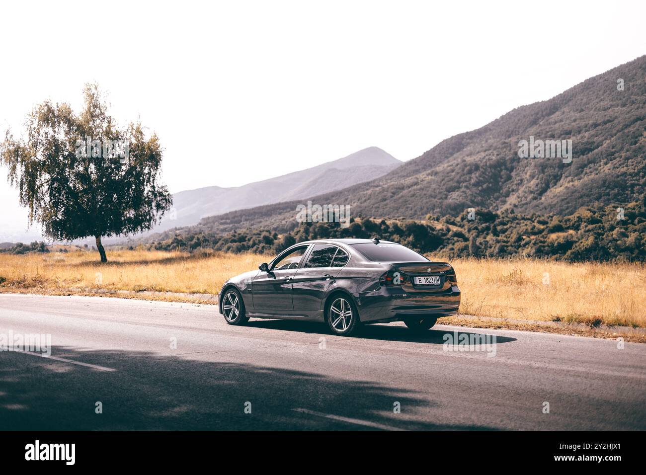 Bulgarie - 10 02 2024 : magnifique paysage avec une BMW e90 grise garée sur le bord de la route. Banque D'Images