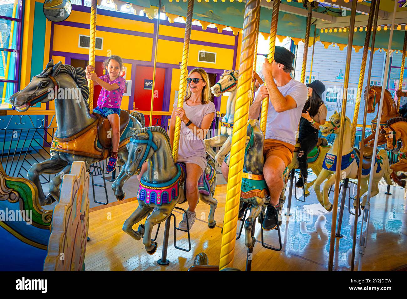 Balade familiale en carrousel à cheval traditionnelle, joyeux tour Banque D'Images