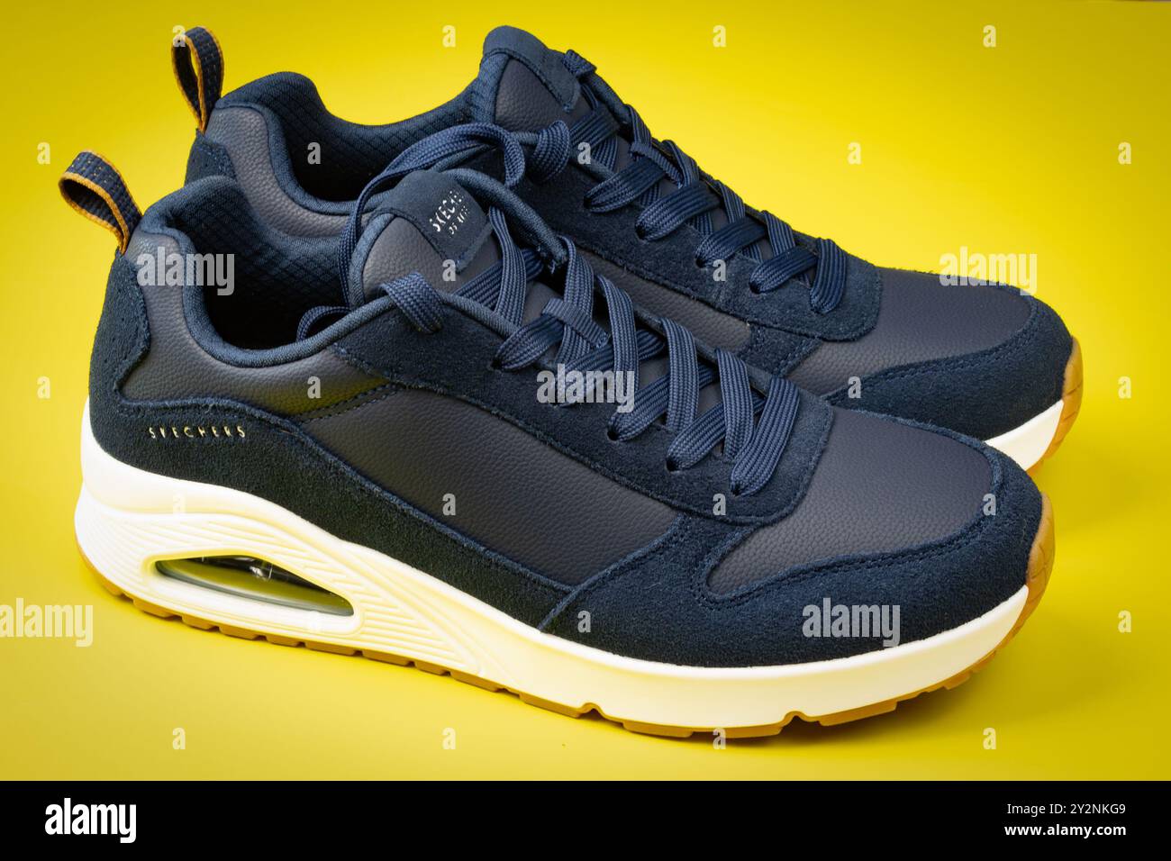 Chaussures de sport de marque Skechers, gros plan, sur fond jaune Banque D'Images