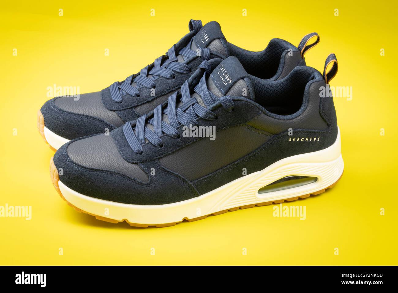 Chaussures de sport de marque Skechers, gros plan, sur fond jaune Banque D'Images