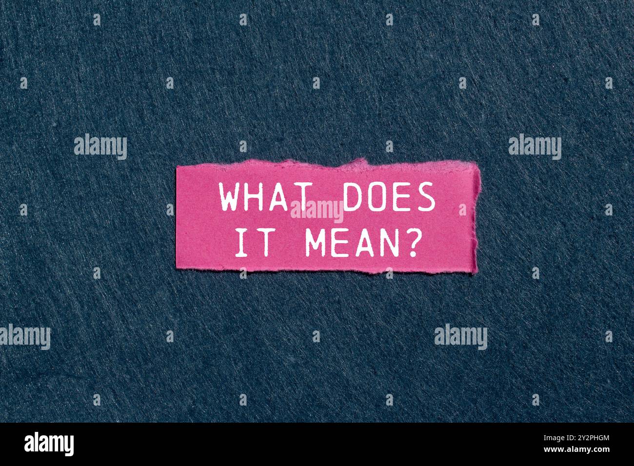 Qu'est-ce que cela signifie question écrite sur un morceau de papier déchiré rose déchiré sur fond gris. Conceptuel qu'est-ce que cela signifie symbole de question. Copier l'espace. Banque D'Images