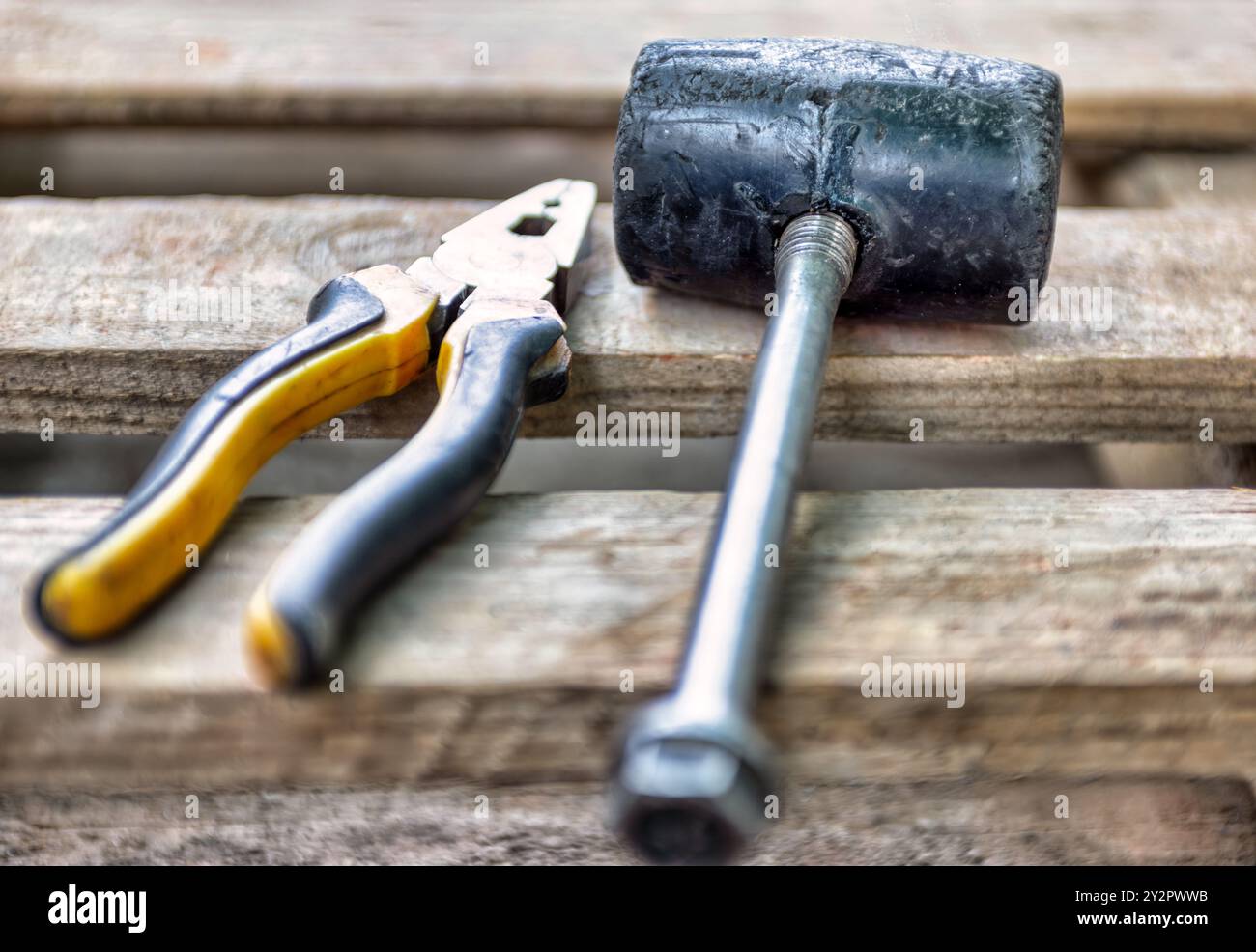 outils usagés , marteau en caoutchouc et pinces sur planches de bois Banque D'Images