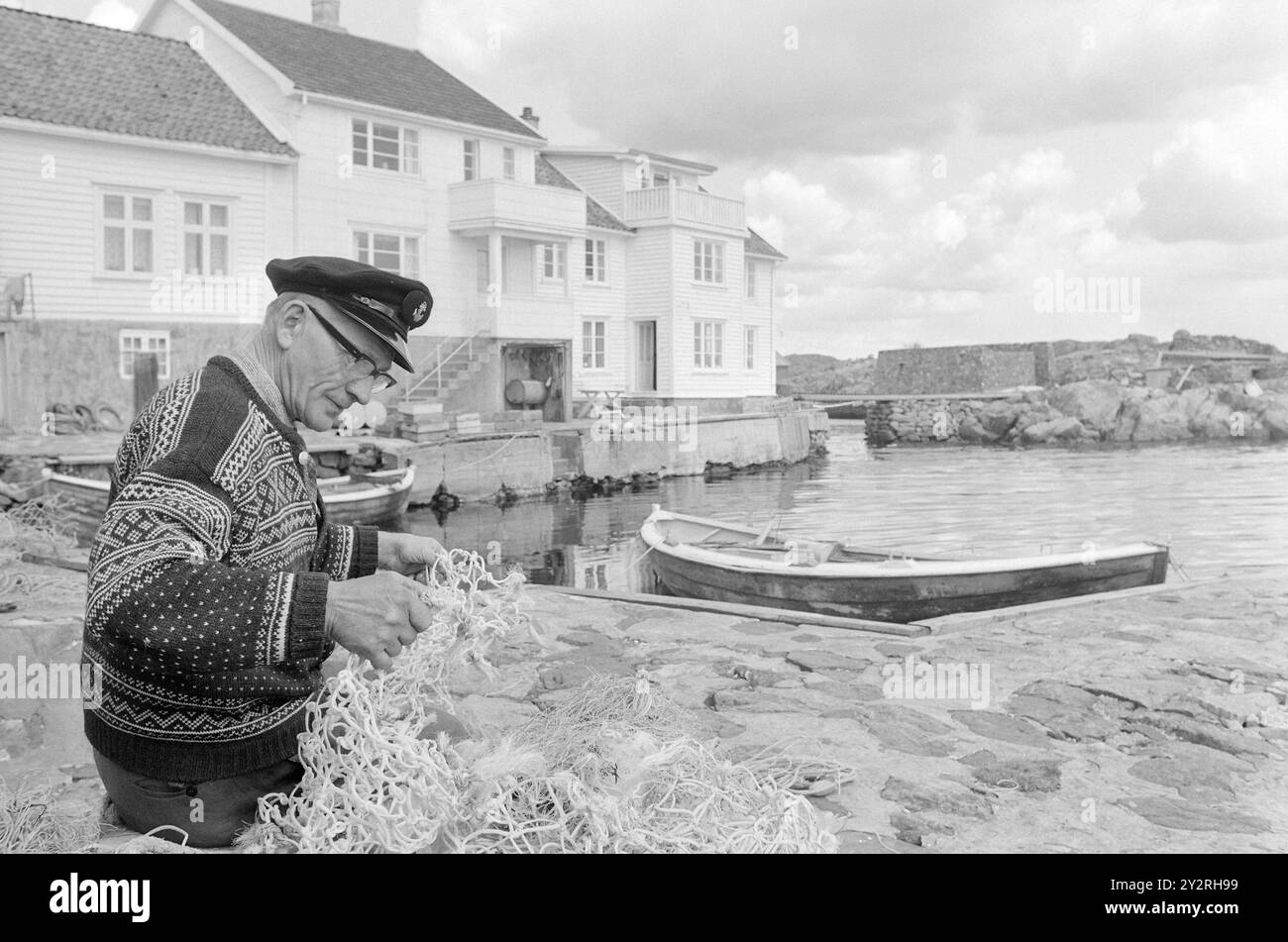 Réel 21 - 5 - 1971 : Sjørøver-HavnaLoshavn à Vest-Agder était autrefois un nid de corsaire. Maintenant, c'est un complexe idyllique avec seulement 33 résidents permanents. Pour les jeunes, une idylle estivale paisible ne suffit pas. Ils partent, et les anciens restent derrière. Victor Wilhelmsen, qui dirige une pension d'été avec sa femme Bolette, répare le matériel de pêche ici. Photo : Sverre A. Børretzen / Aktuell / NTB ***PHOTO NON TRAITÉE*** le texte de cette image est traduit automatiquement Banque D'Images