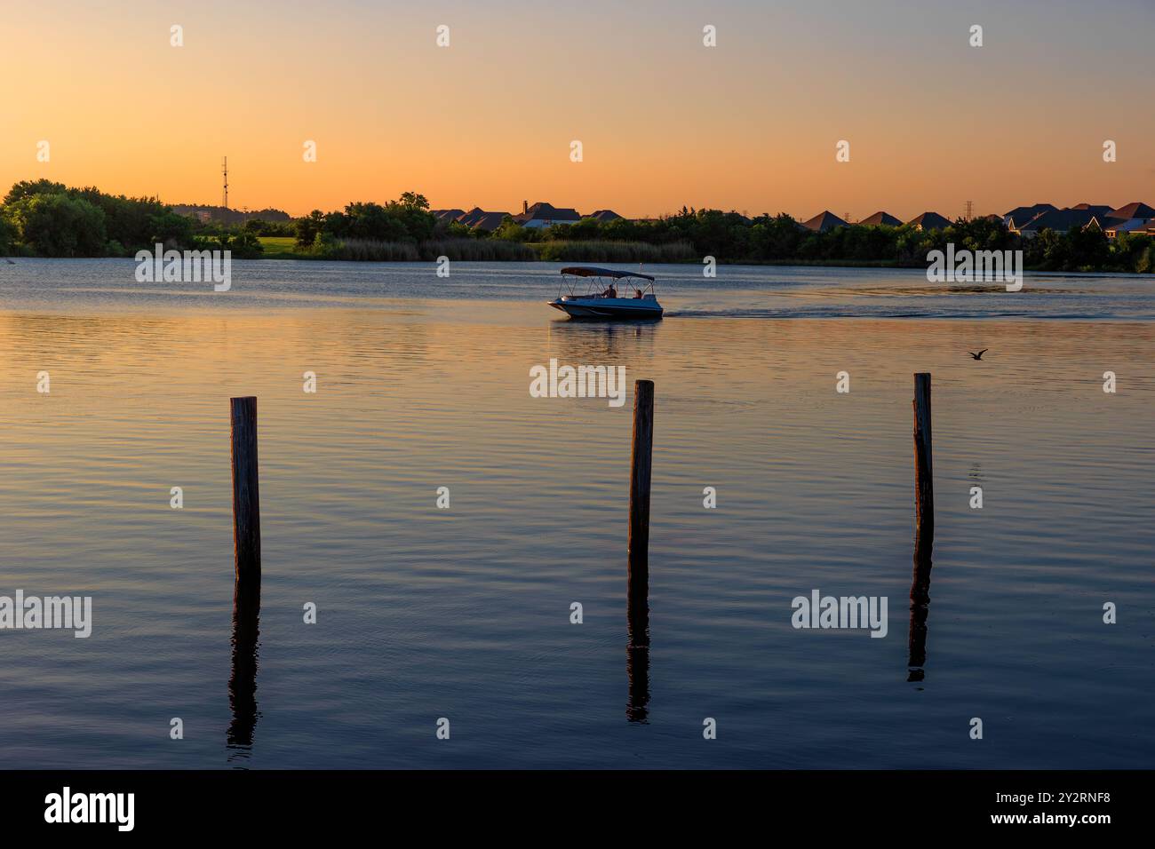 League City, Texas, États-Unis - 22 juin 2024 : le bateau se déplace le long de l'eau du bayou au crépuscule. Banque D'Images