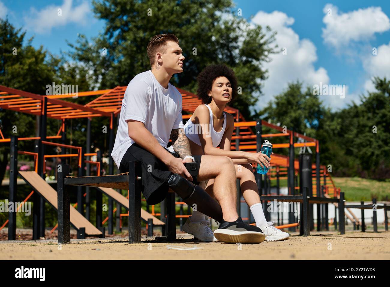 Les amis prennent une pause après un entraînement intense en plein air, embrassant la diversité dans la forme physique. Banque D'Images