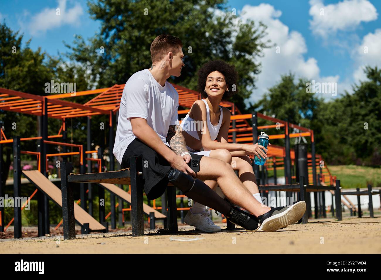 des amis heureux prennent une pause après l'entraînement en plein air, embrassant la diversité dans la forme physique. Banque D'Images