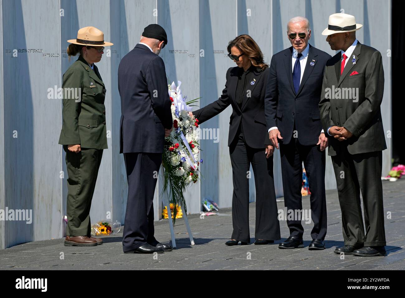 President Joe Biden, second from right, and Democratic presidential nominee Vice President Kamala Harris, third from left, place a wreath at the Flight 93 National Memorial Wall of Names accompanied by family members of Flight 93 passengers Patrick White, cousin of Louis Nache, second from left, and Calvin Wilson, cousin of first officer Leroy Homer, right, in Shanksville, Pa., Wednesday, Sept. 11, 2024. (AP Photo/Gene J. Puskar) Banque D'Images