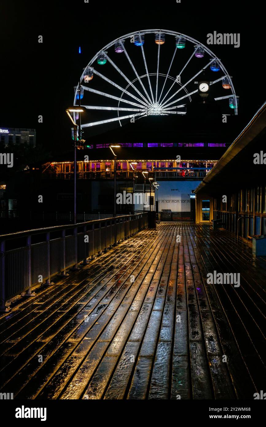 Jetées britanniques en bord de mer, jetée de Bournemouth la nuit, reflets pluvieux, grande roue Banque D'Images