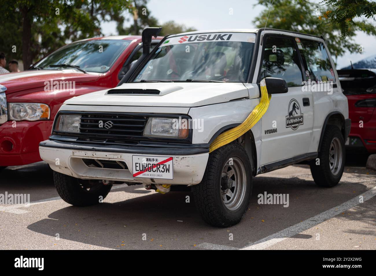 Nice et classique japonais hors route Suzuki Vitara en blanc avec une sangle de remorquage jaune et un tuba Banque D'Images